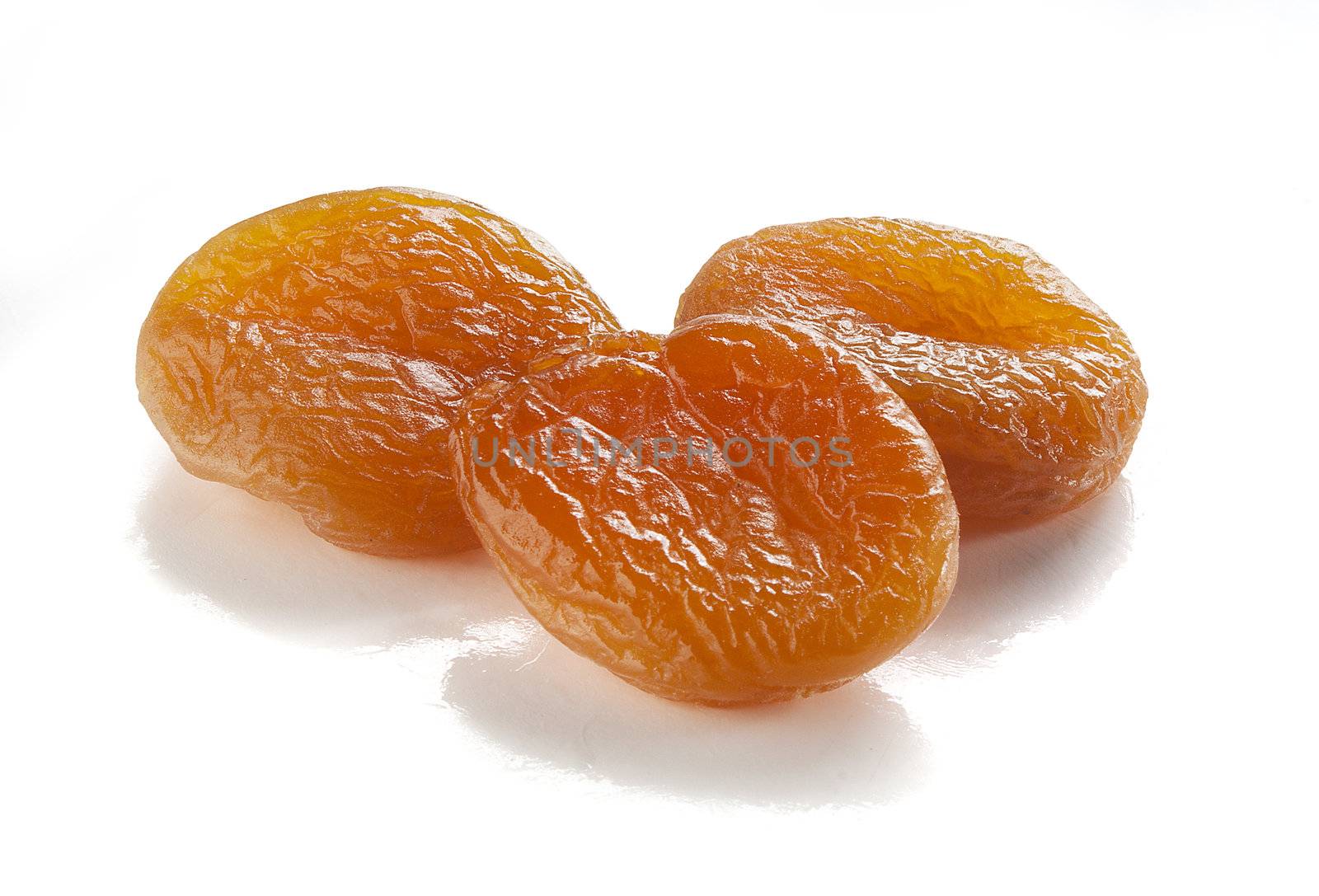 Three dried orange apricots on the white background