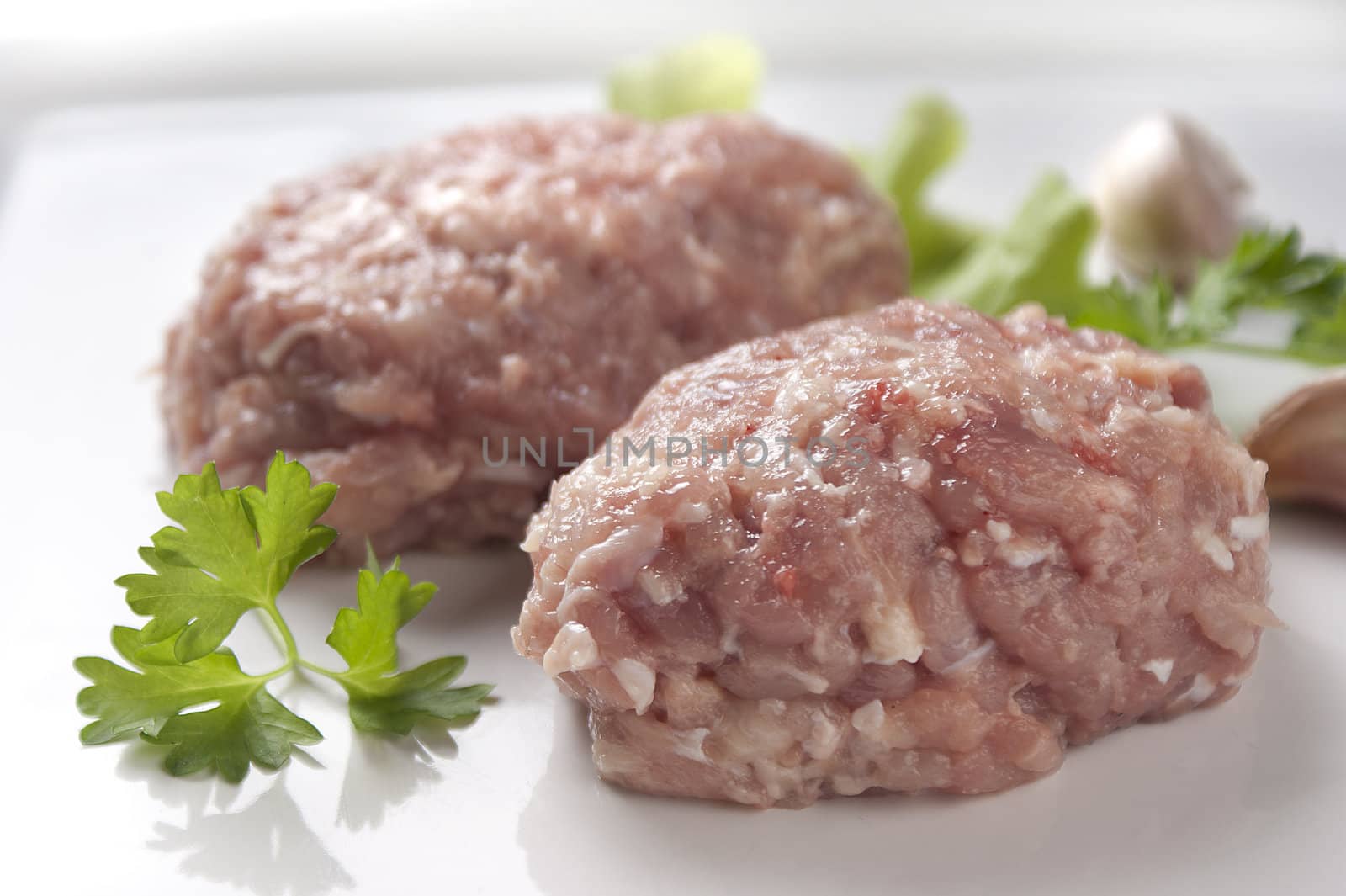 Two raw chicken rissole with parsley and garlic