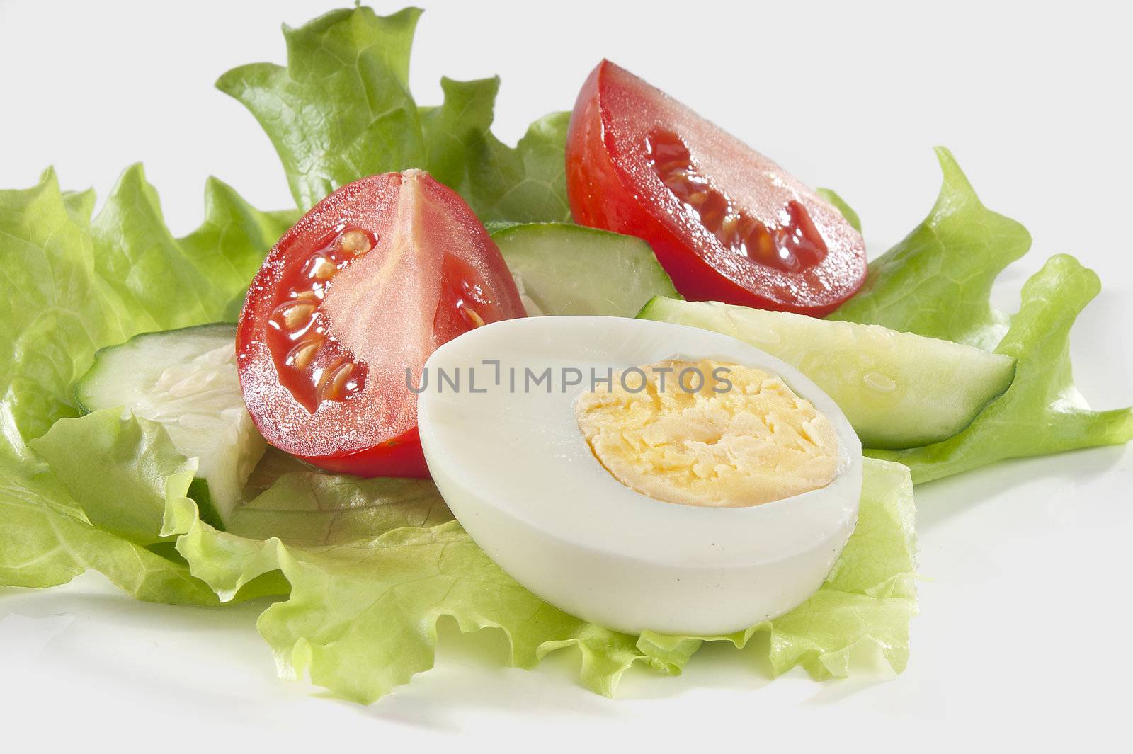 Half of boiled egg with vegetables on the lettuce