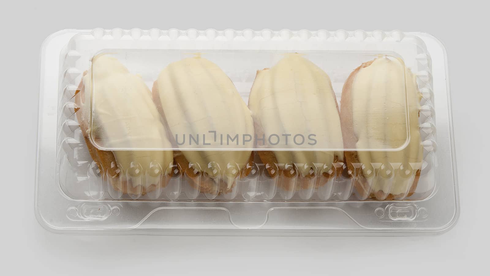 Four cream-filled French pastry in the transparent plastic box