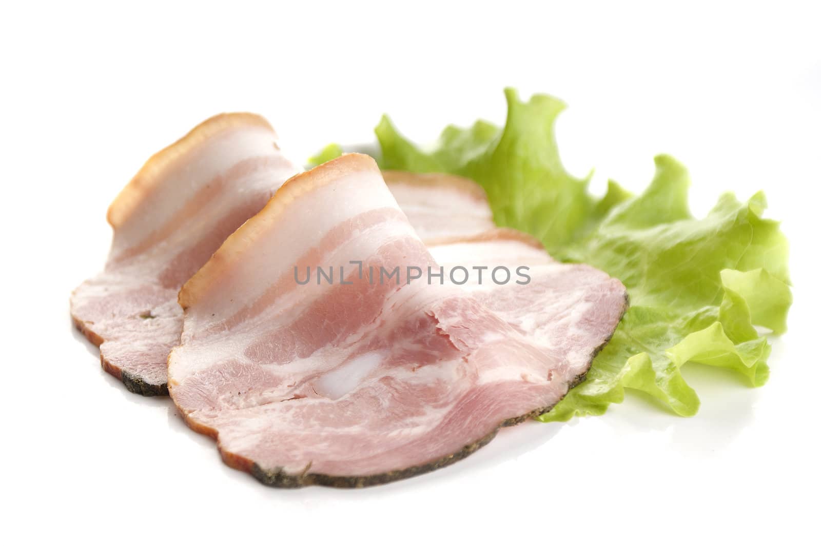 Two pieces of bacon on the fresh lettuce