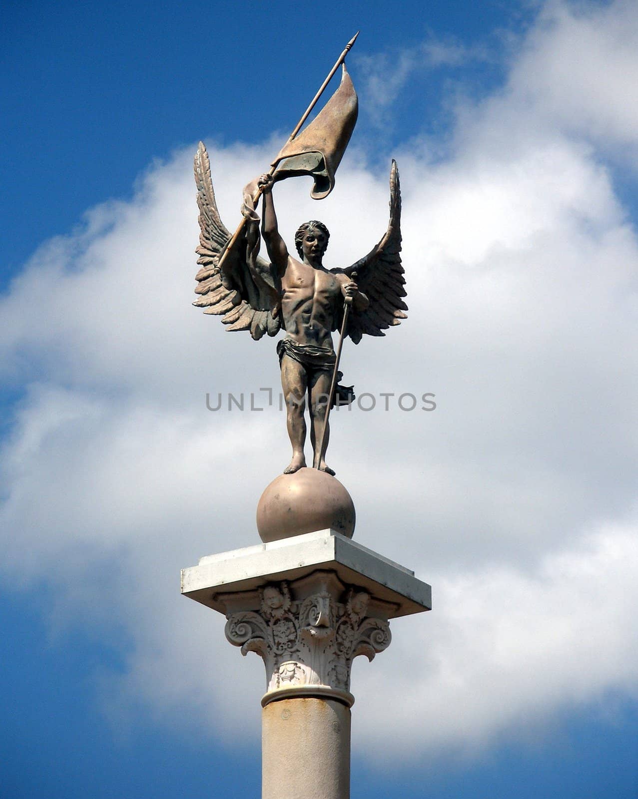 An angel statue with blue sky and clouds as the background.