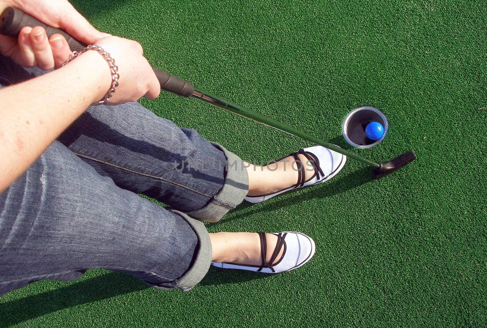 Putting a ball at an adventure golf.