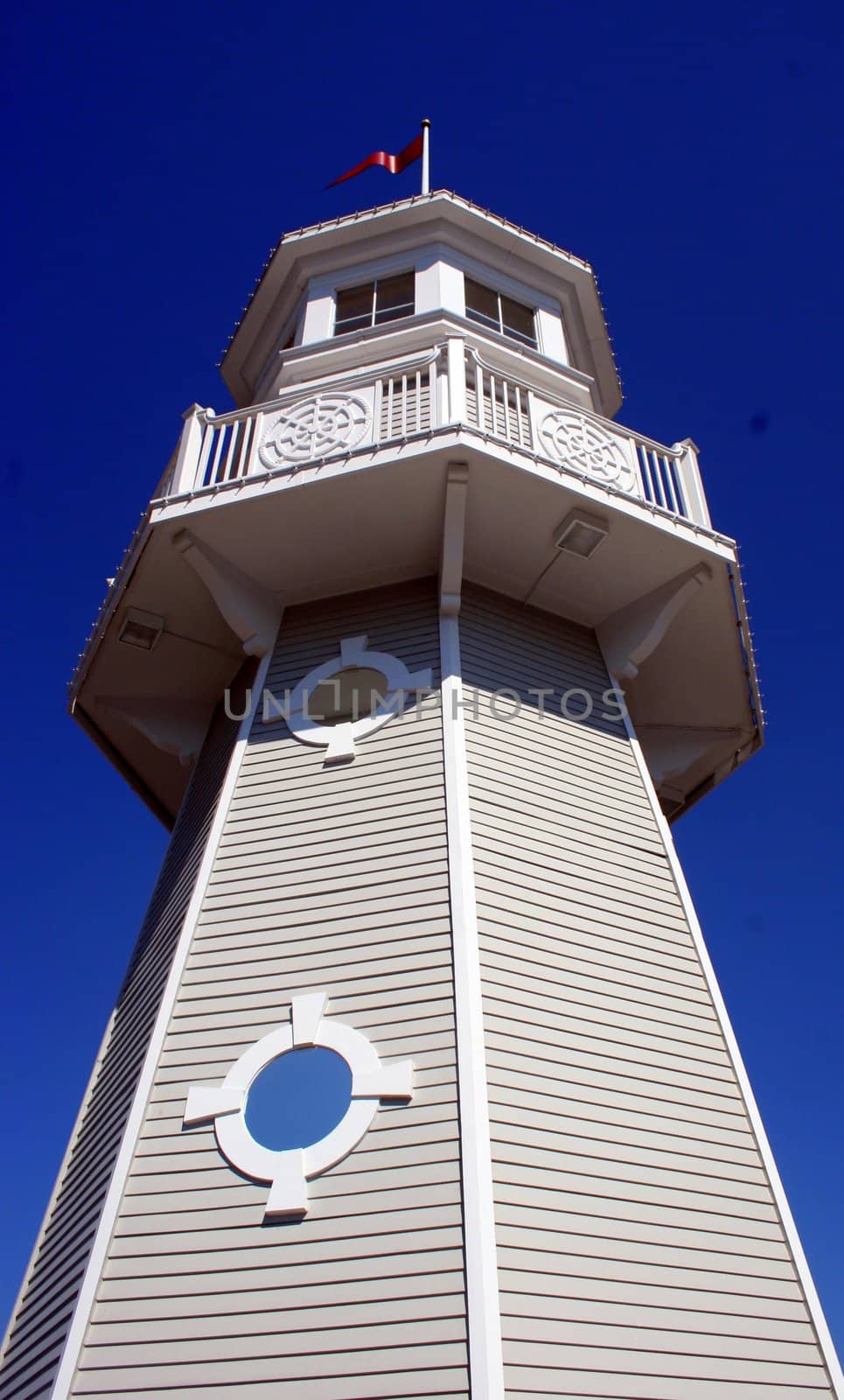 A lighthouse with pure blue sky upward view.