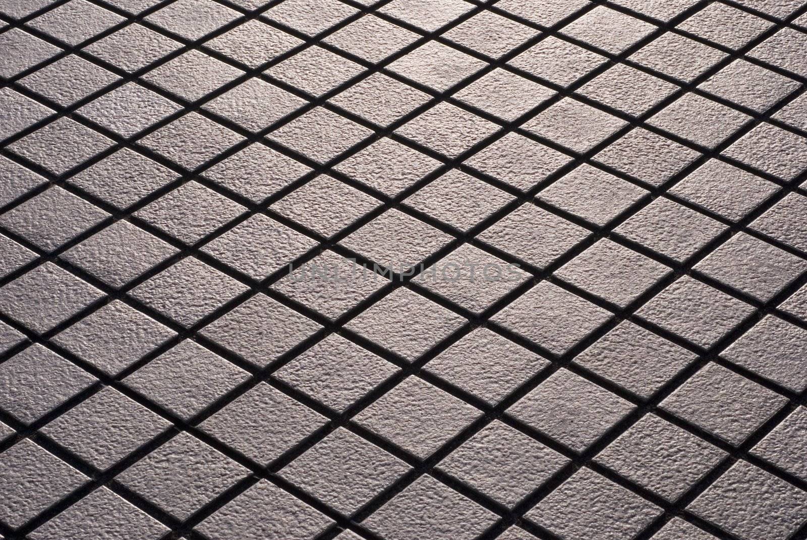 Criss-crossed design of diamond shaped street tiling.