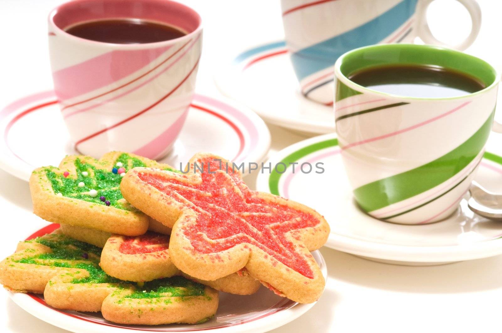 Plate of colorful christmas sugar cookies and coffee.