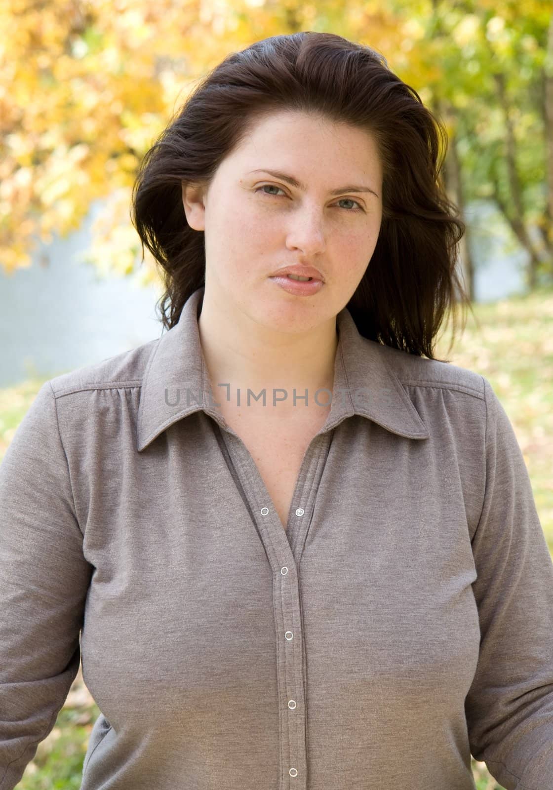 Autumn. Beautiful young woman against yellow leaves.