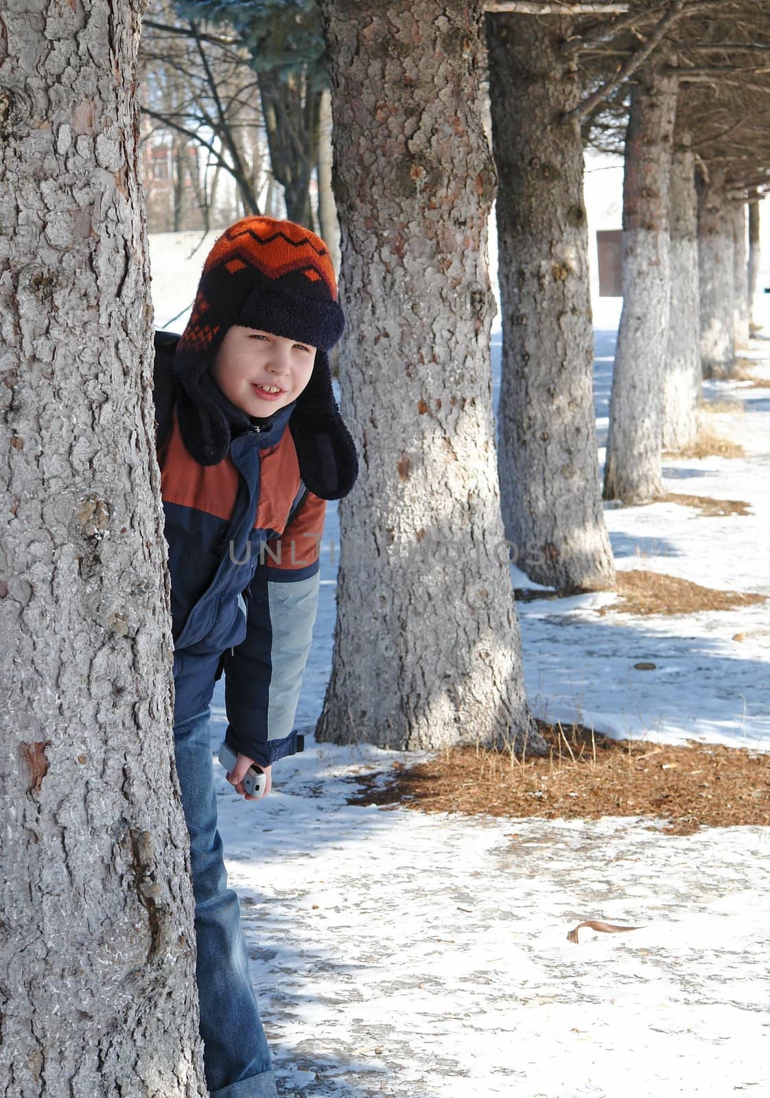 Winter. The smiling little boy against trees.