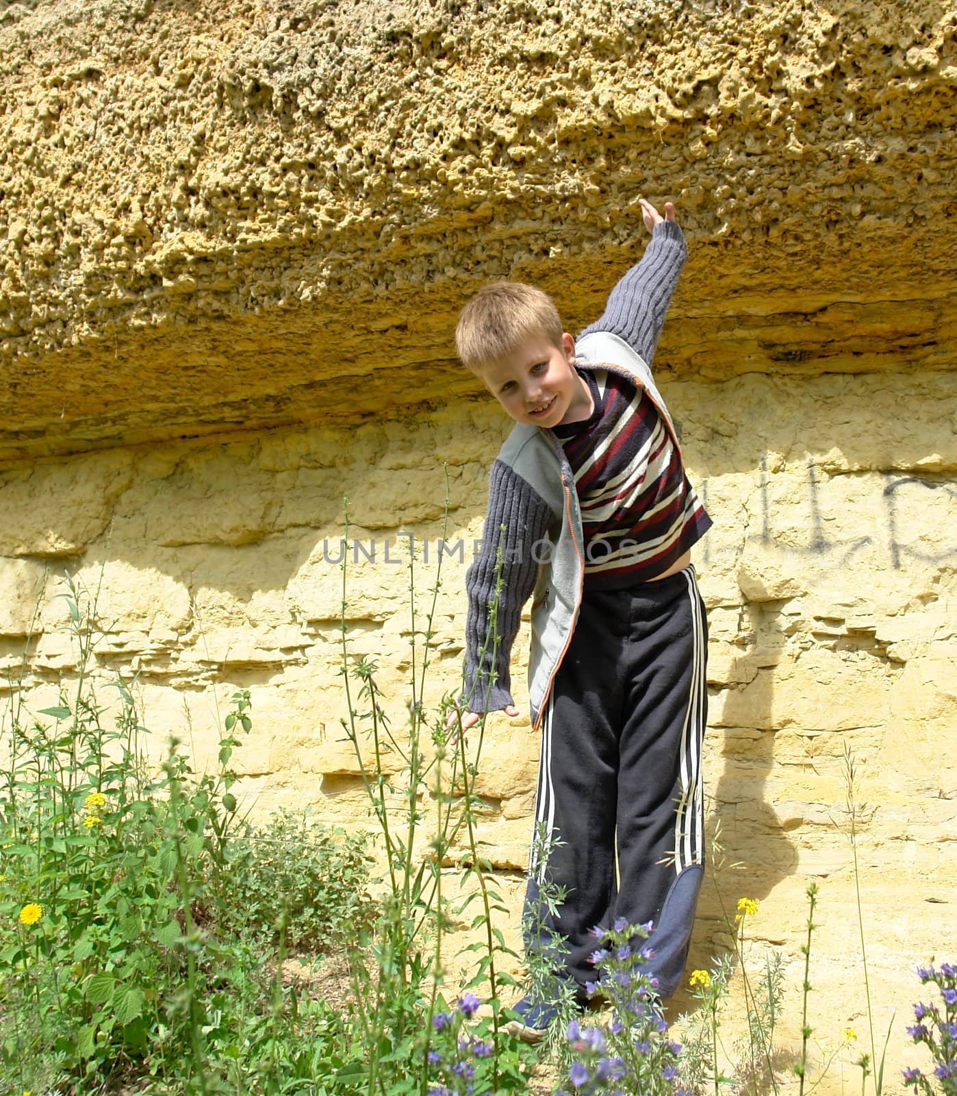 The smiling little boy against yellow rock