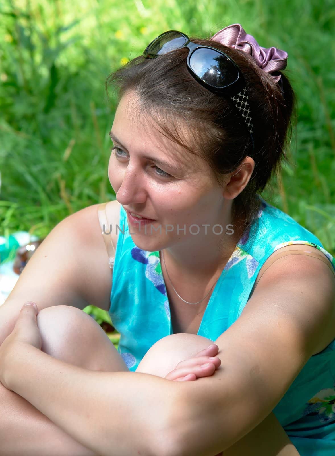 young beautiful woman against green foliage