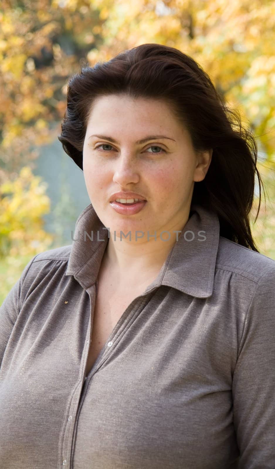 Autumn. Beautiful young woman against yellow leaves.