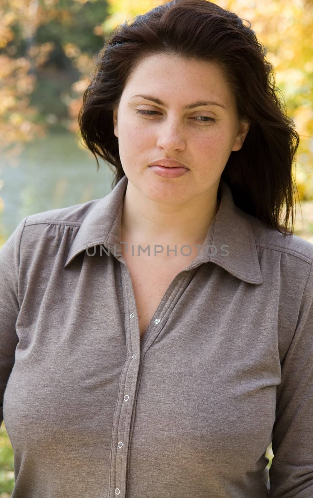 The beautiful young woman against the river