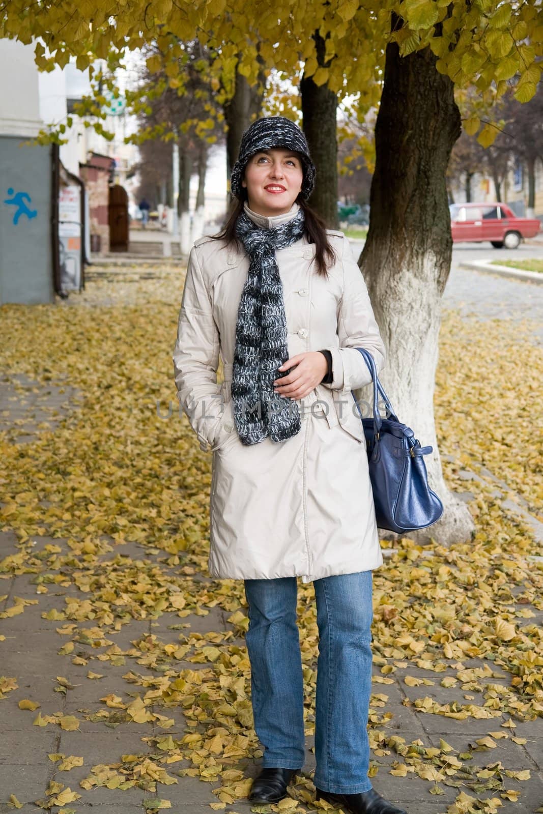 beautiful young woman in autumn city street