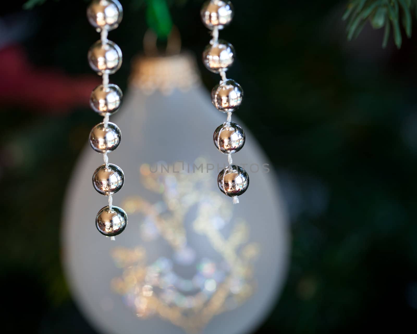 Christmas tree decorated with silver and white ribbons and ornaments in family home