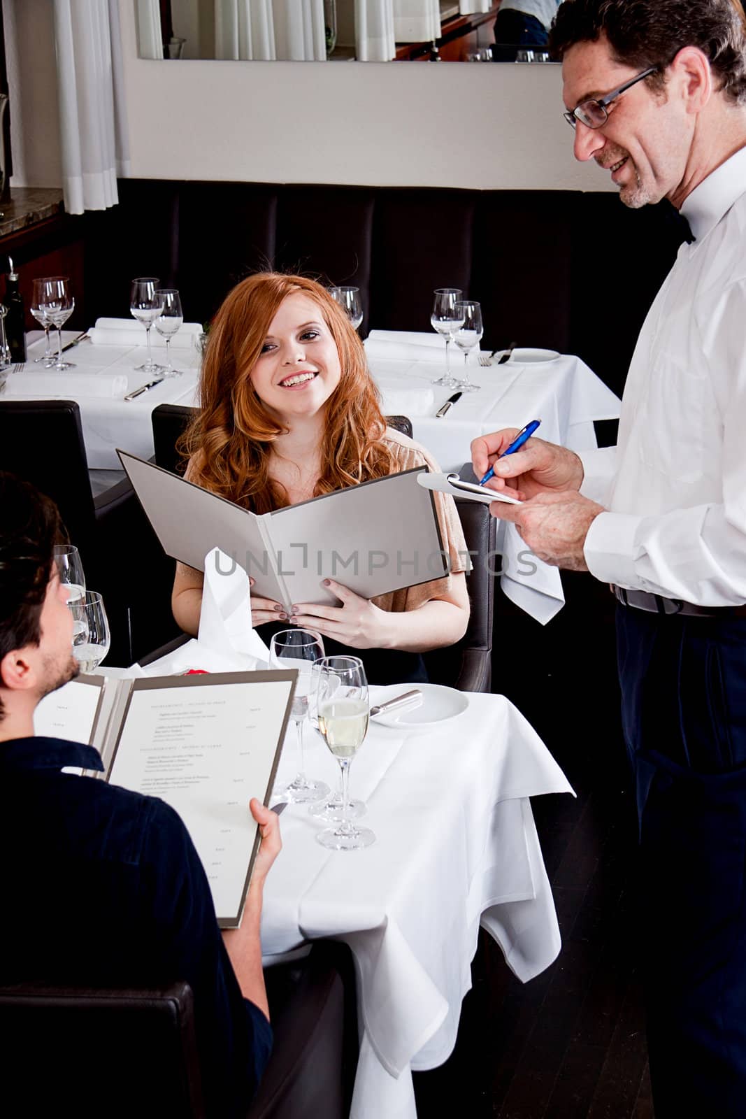 man and woman in restaurant waiter bring card and order food