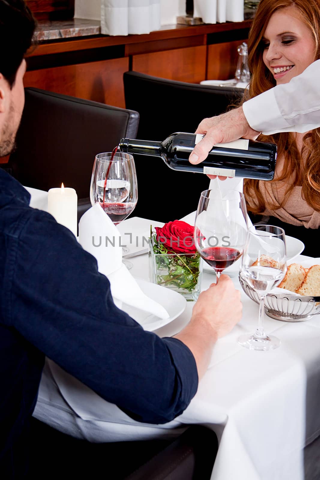 man and woman in restaurant for dinner drinking red wine and smiling