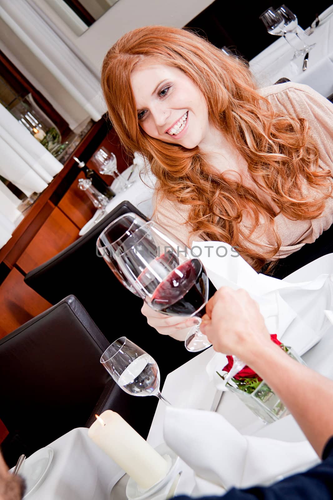 man and woman in restaurant for dinner drinking red wine and smiling