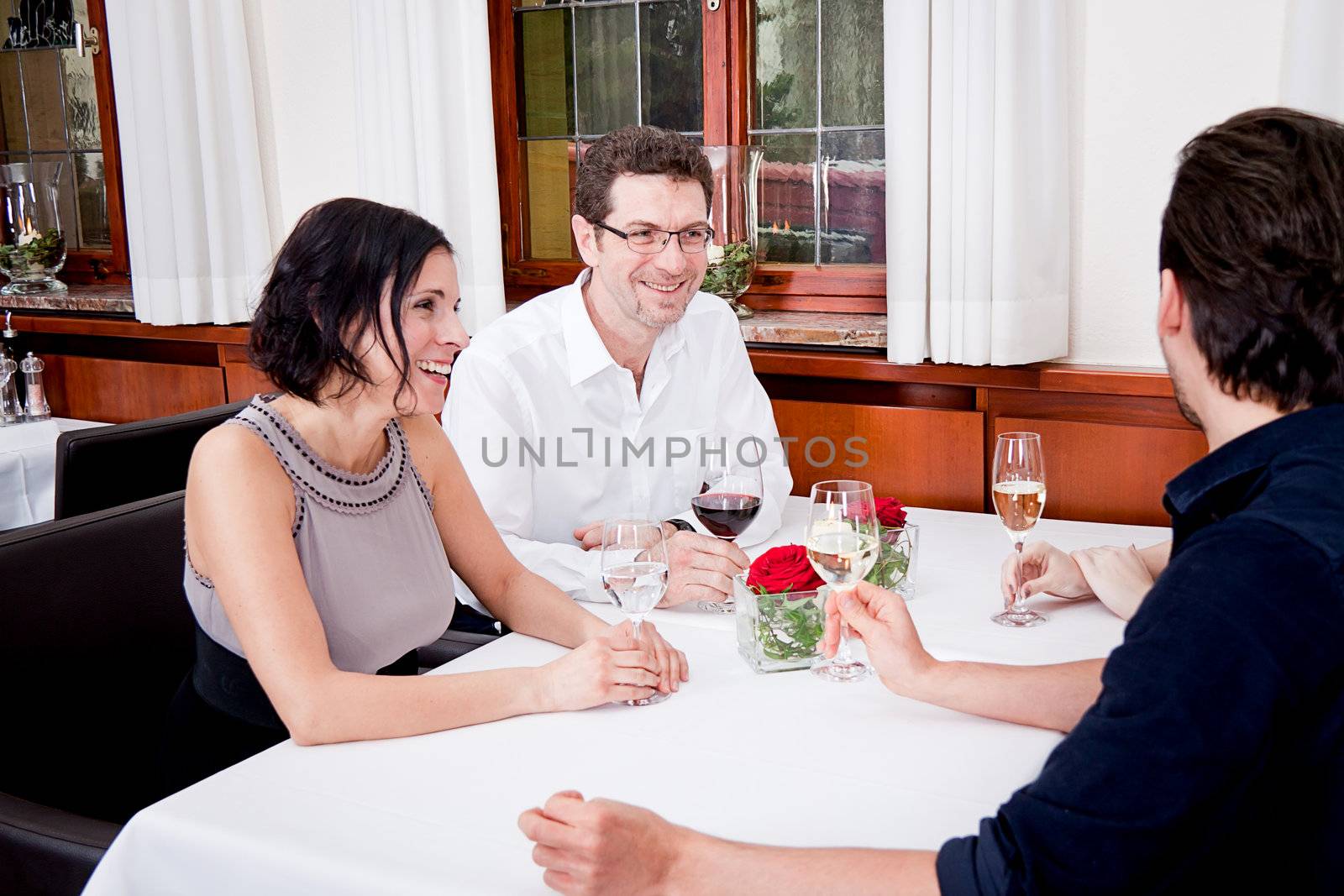 smiling happy people in restaurant drinking talking having fun 