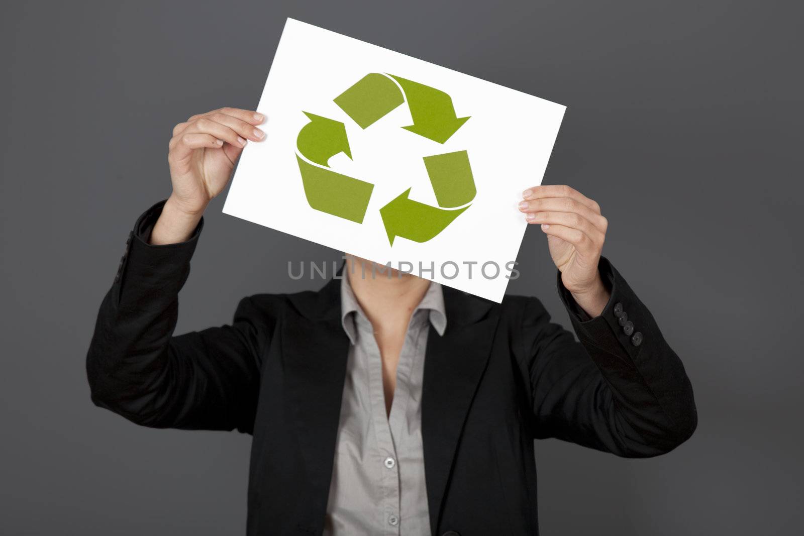 Woman holding a sheet of paper with the recycling symbol