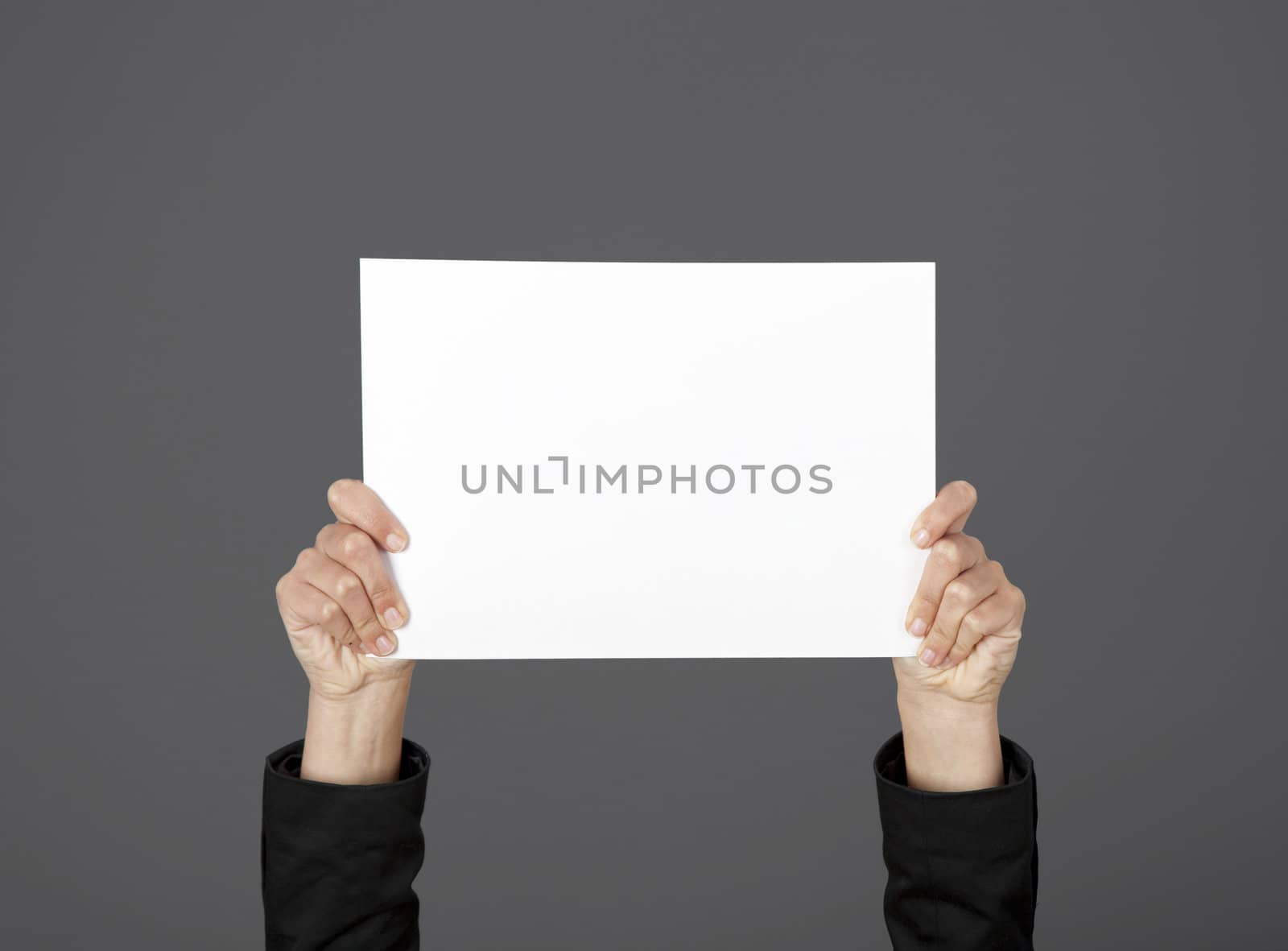 Woman holding a blank paper sheet with both hands