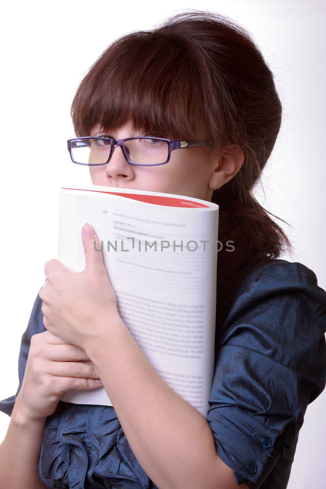 Portrait of young alluring brunette woman, holding book on white background