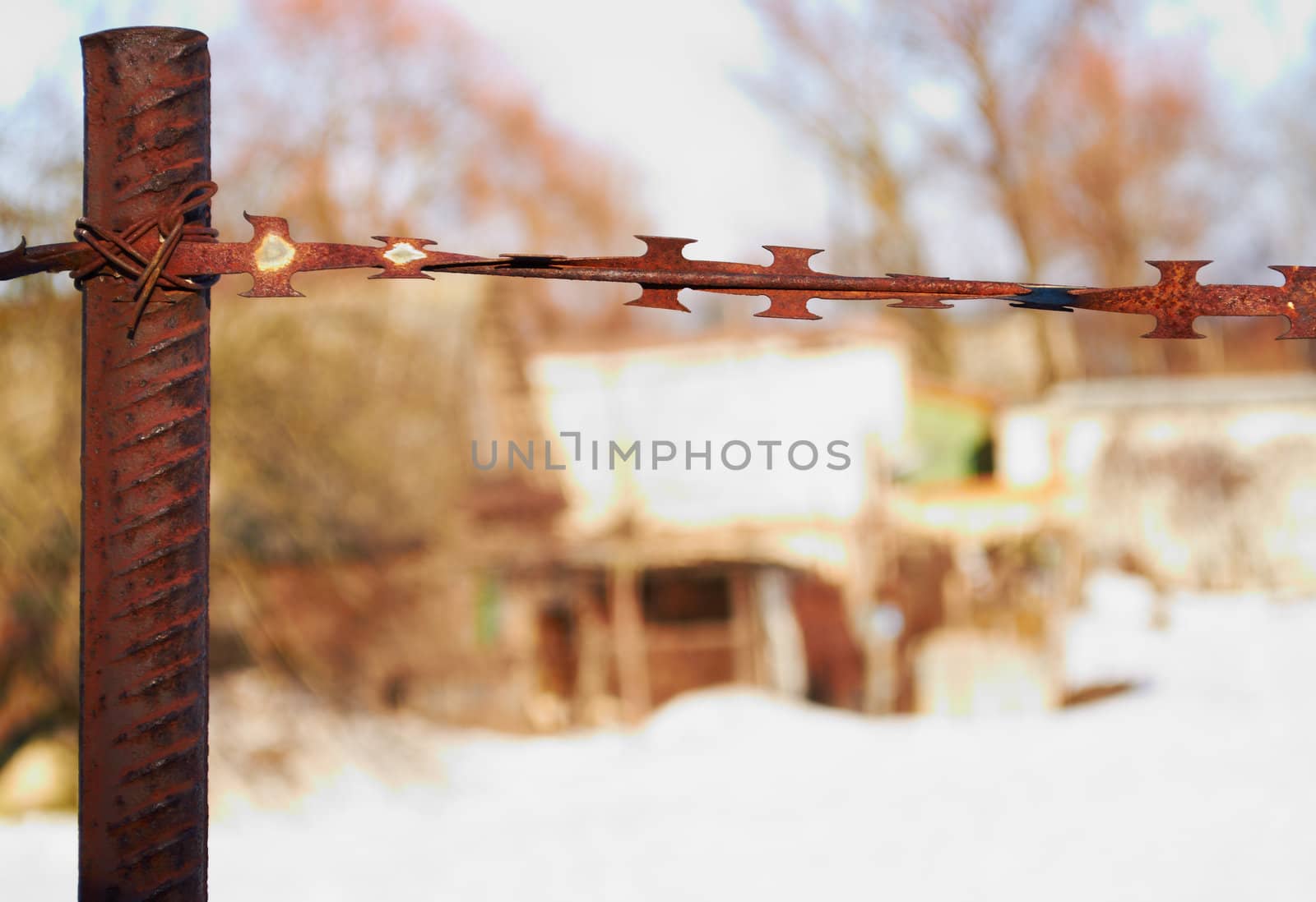 Rusty barbed wire fence enclosing private property