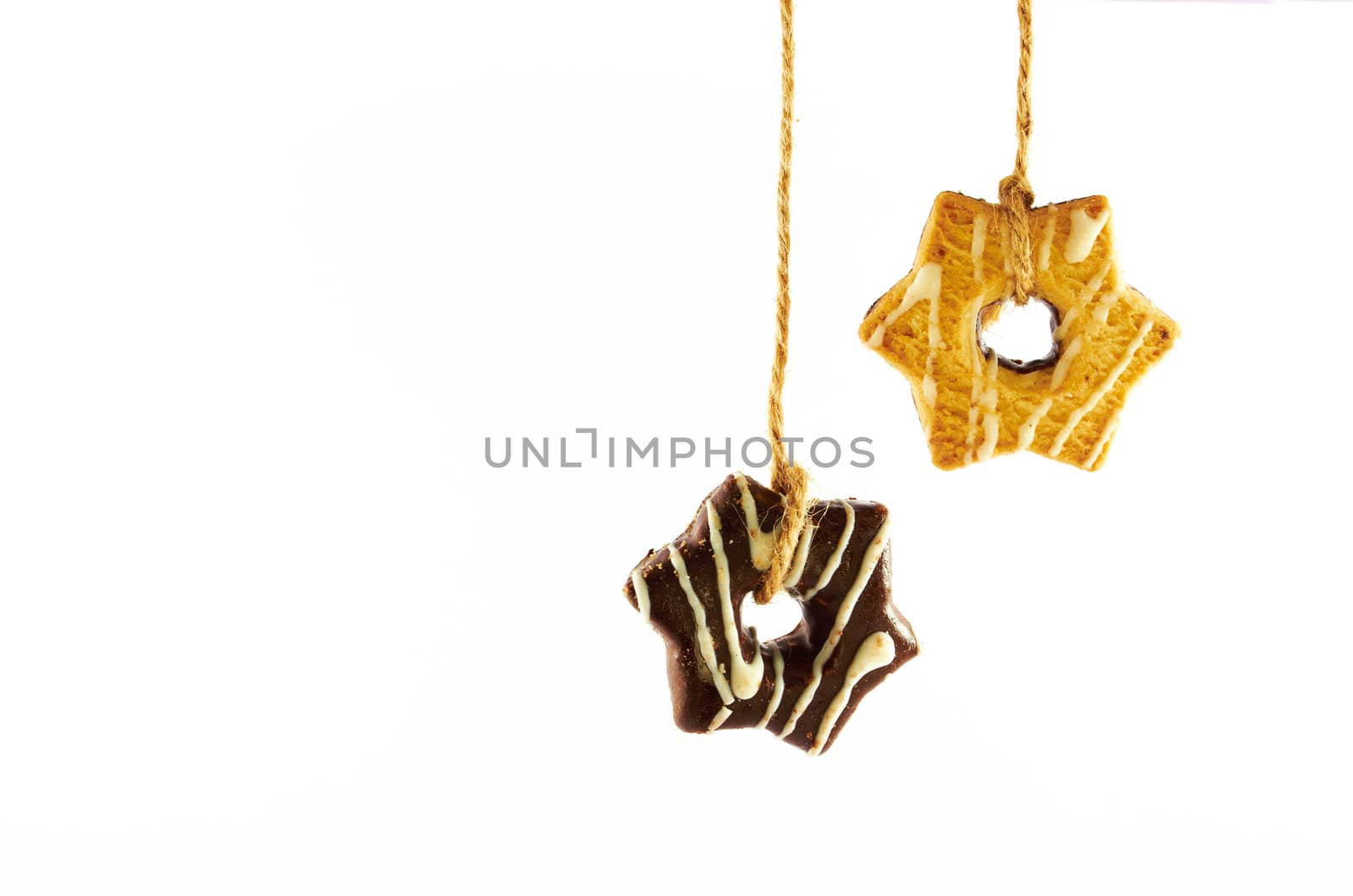 Shortbread cookies with milk and chocolate glaze hanging on a rope on a white background