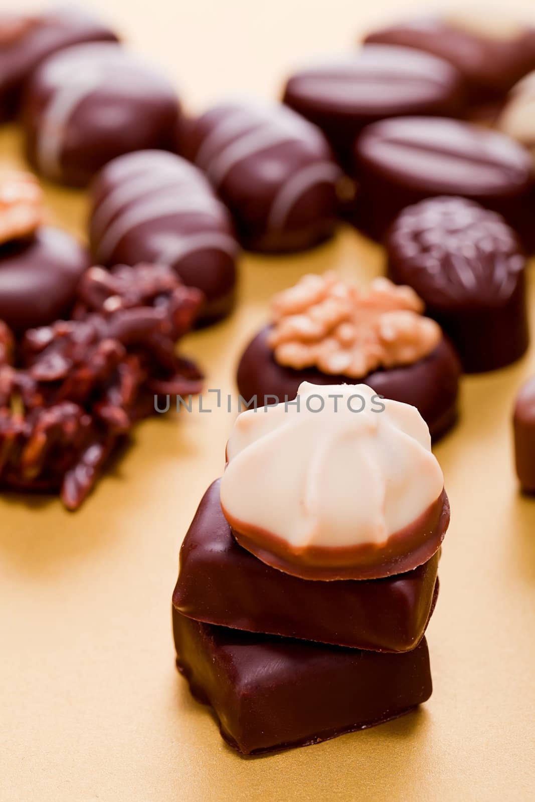 collection of different chocolate pralines truffels on golden brown background macro
