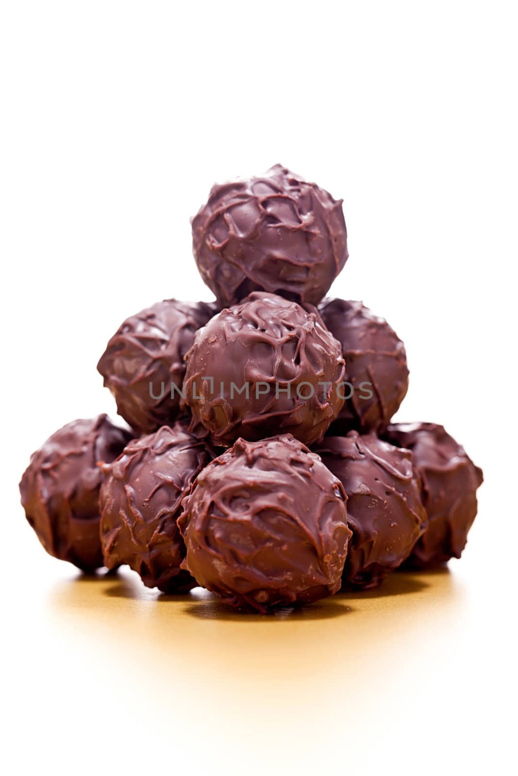 collection of different chocolate pralines truffels on golden brown background macro