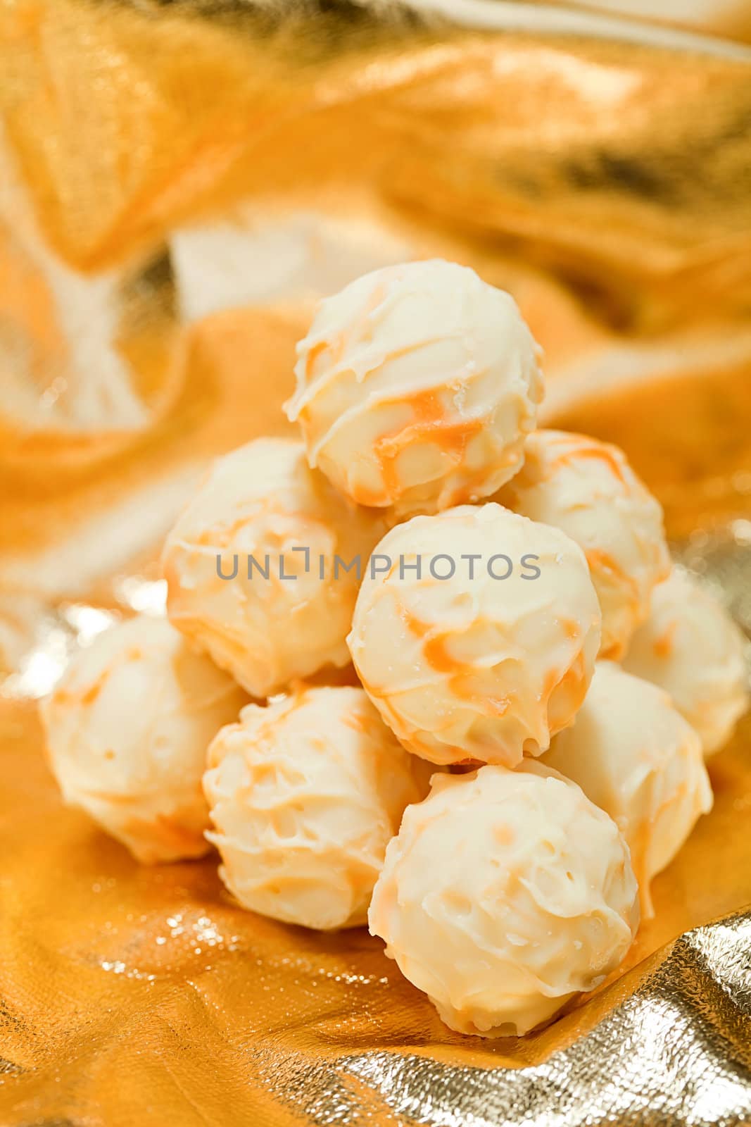 collection of different chocolate pralines truffels on golden brown background macro