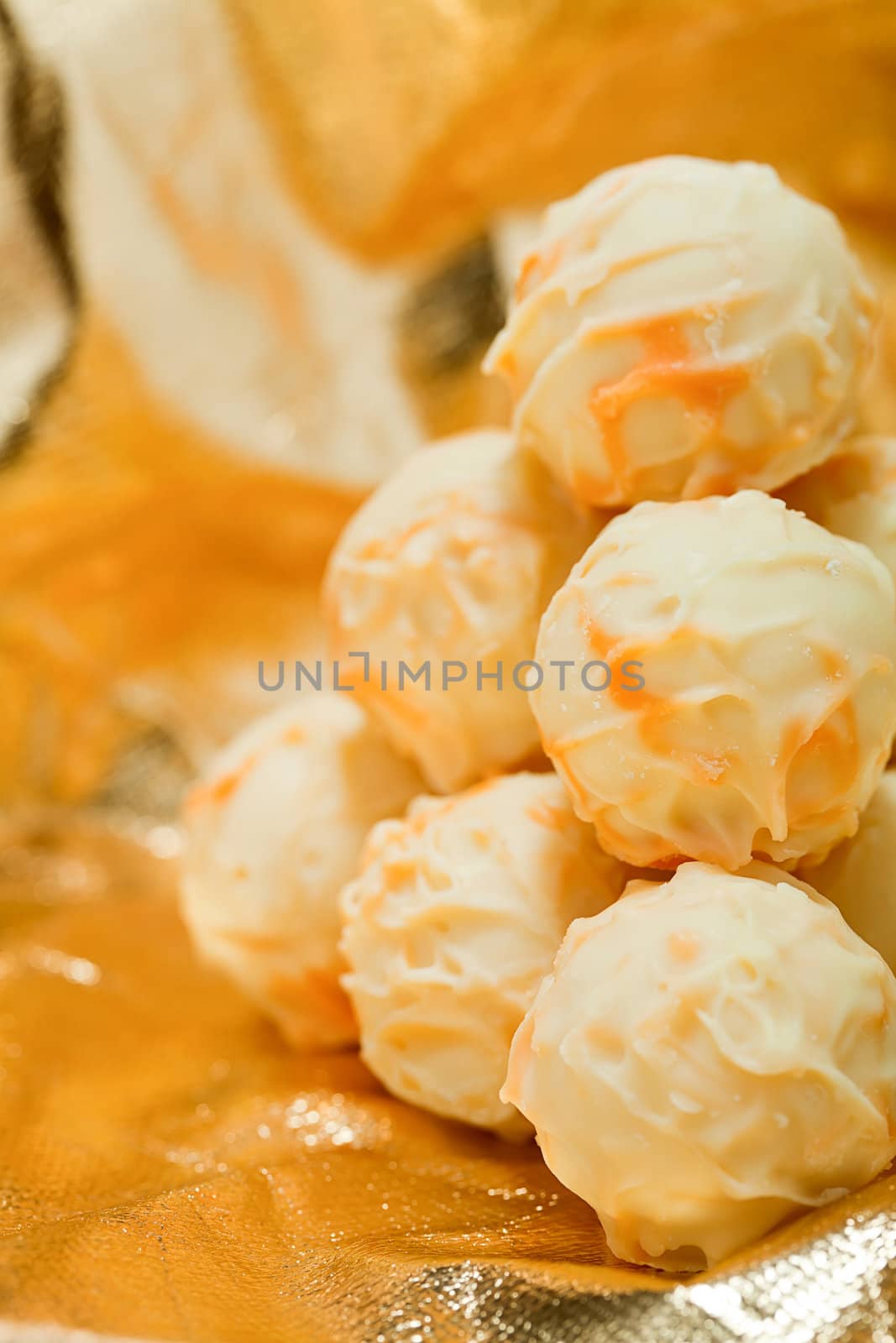collection of different chocolate pralines truffels on golden brown background macro