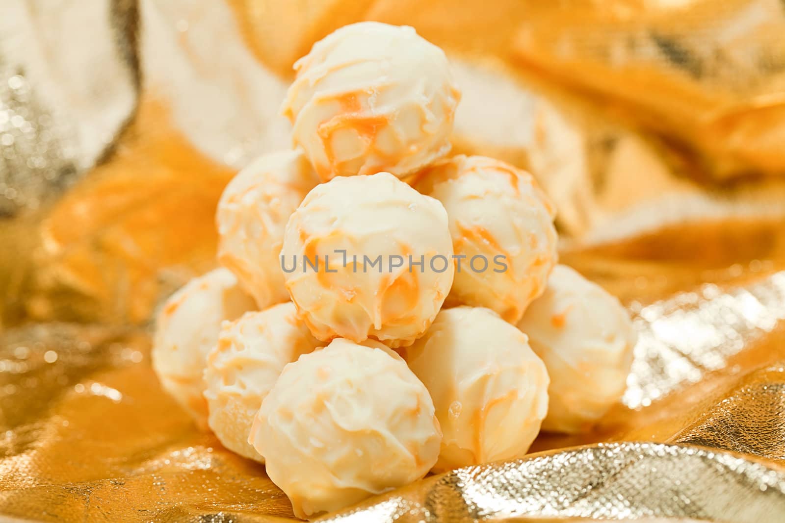 collection of different chocolate pralines truffels on golden brown background macro