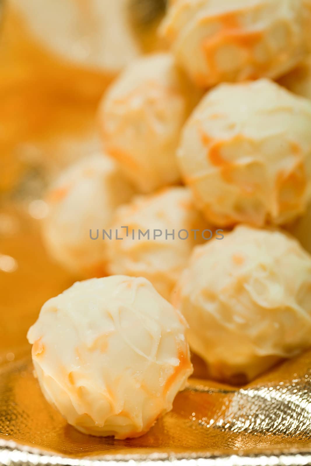 collection of different chocolate pralines truffels on golden brown background macro