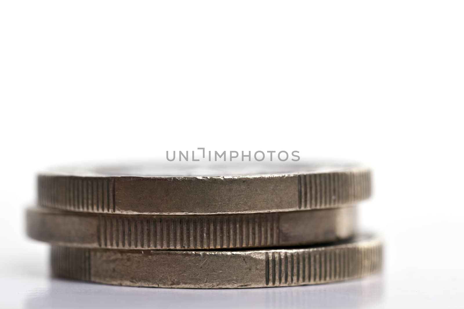 Stack of three 1 Euro coins over a plain background