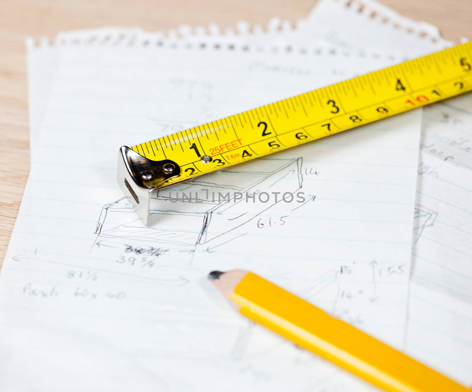 Tape measure and pencil laying on plans for a woodworking project