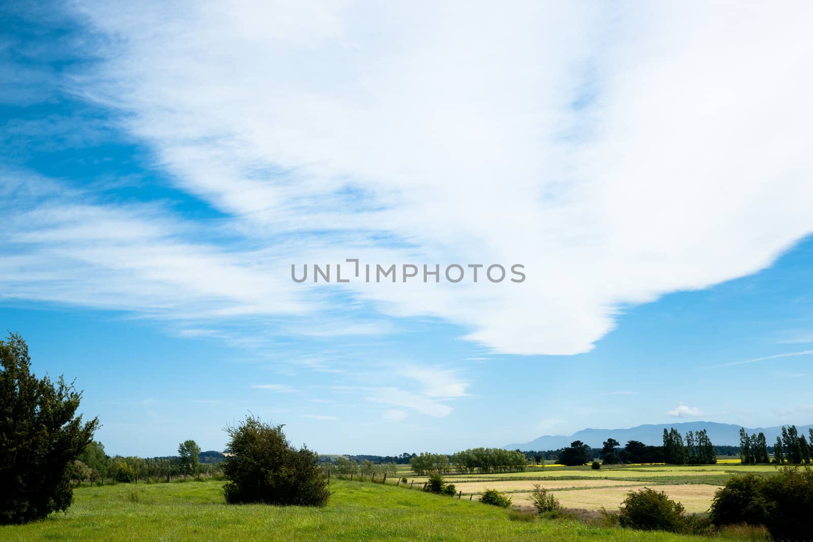 White cloud patterns above a rural landscape