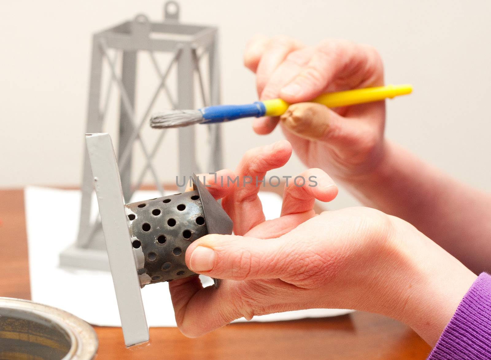 hands painting lantern