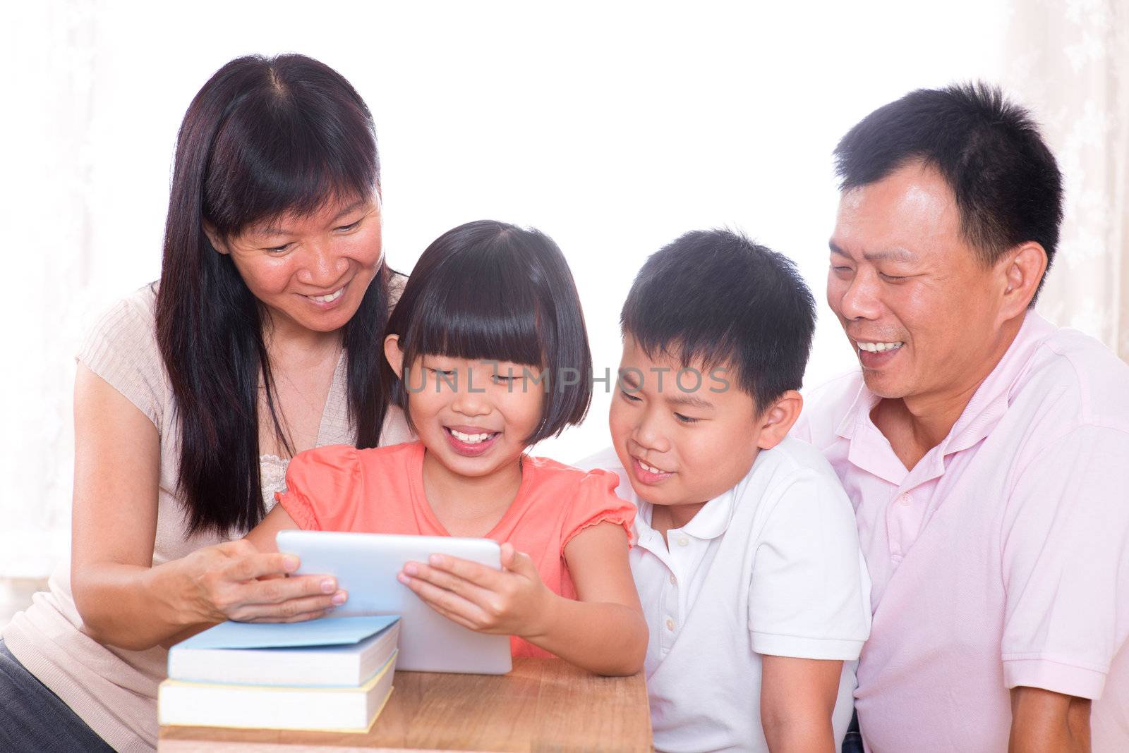  Parents and children using tablet pc together. by szefei