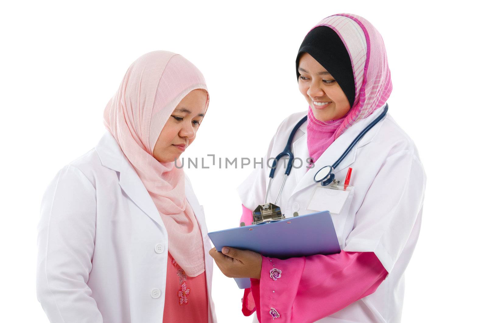 Two Southeast Asian Muslim medical doctors discussing on patient medical report, standing isolated on white background