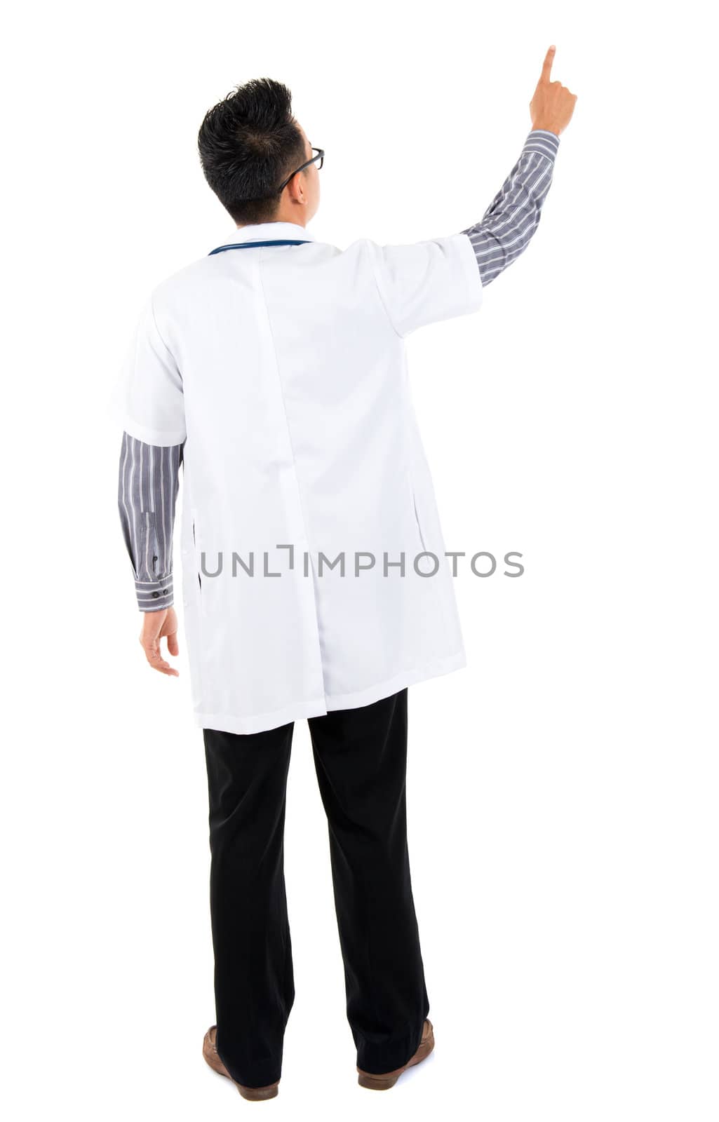 Full body rear view of Asian medical doctor pointing at blank space standing isolated on white background