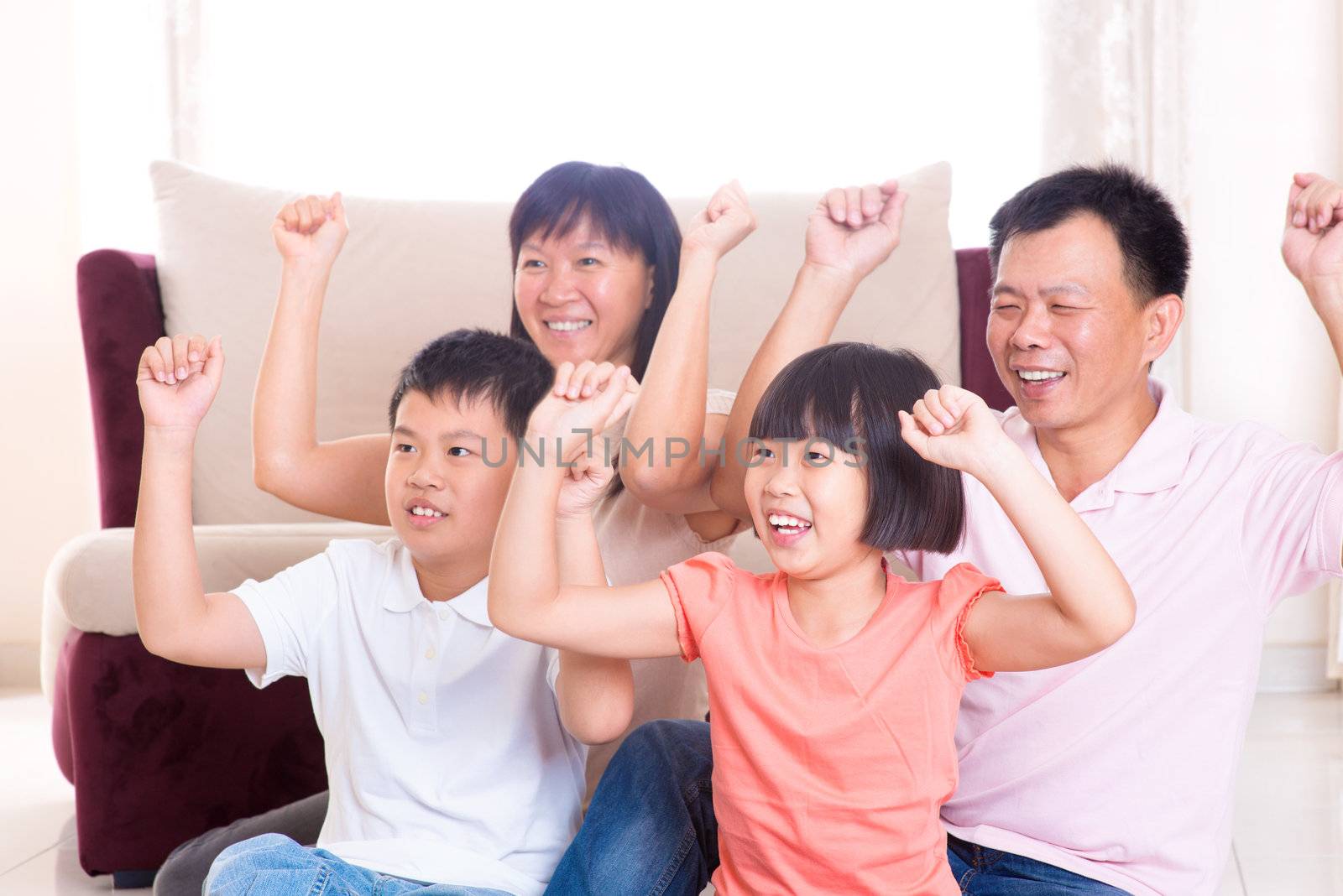 Asian family at home. Portrait of happy parents and children playing game arms raised together at home.