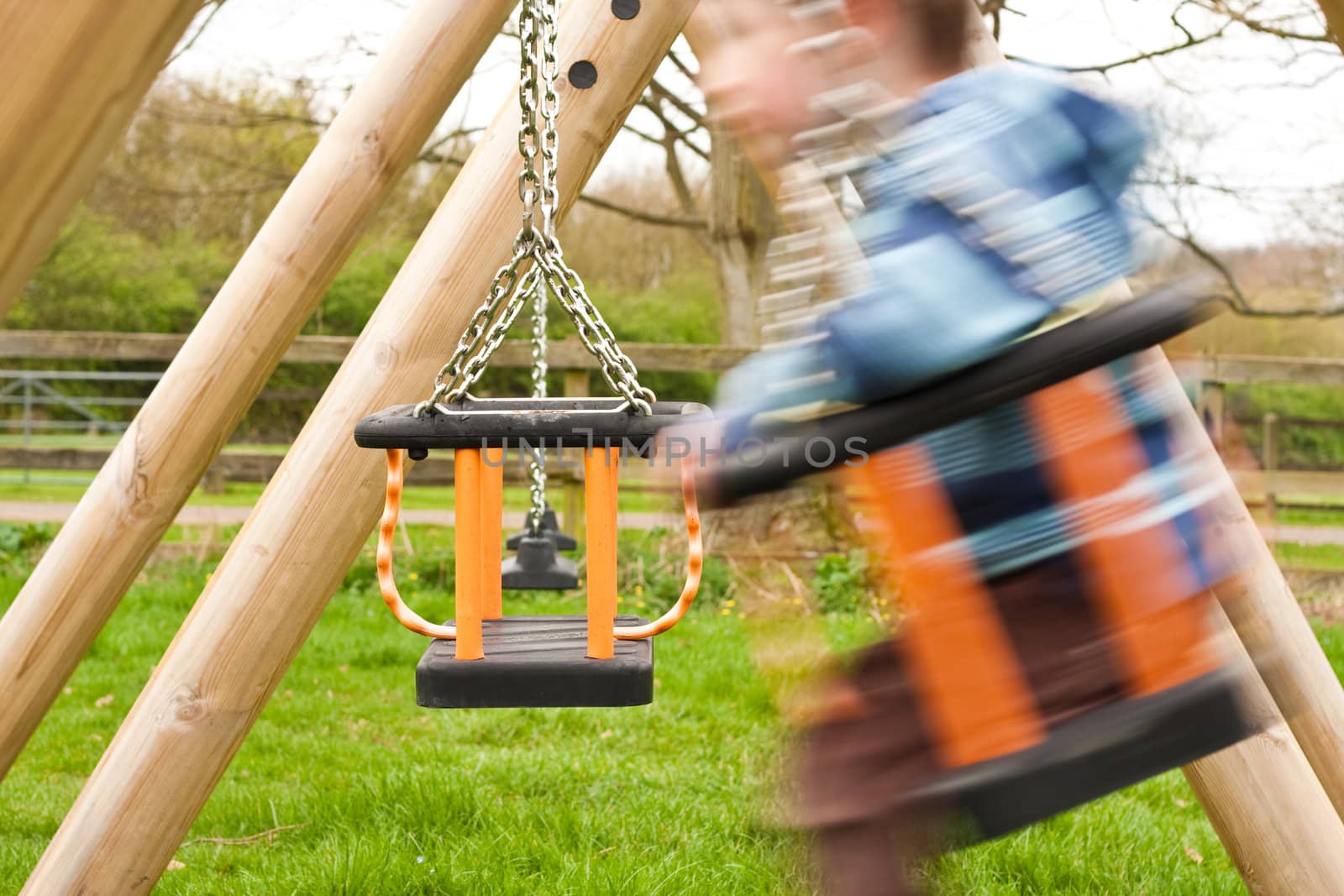 Little boy playing on a swing