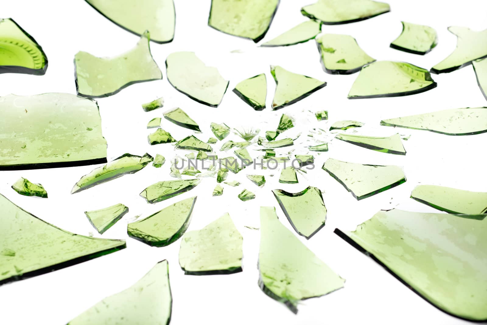Green bottle in smashed in pieces isolated on white
