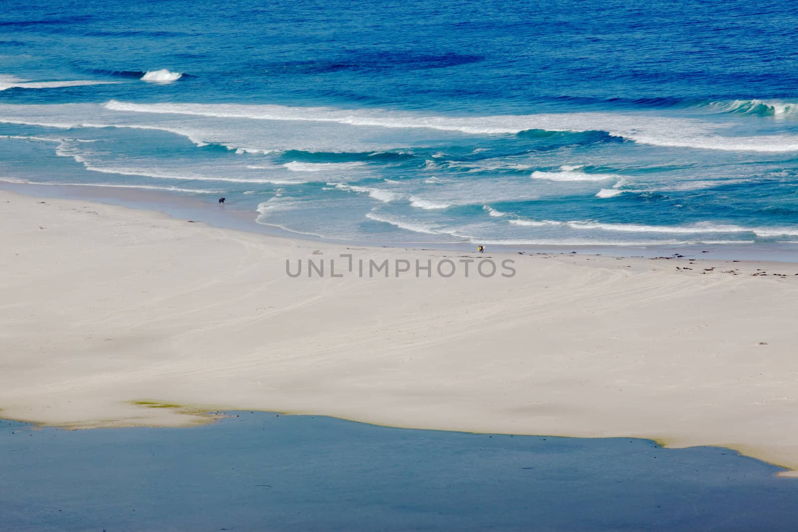 A horse rider and surfer at Long Beach in the Cape Peninsula, South Africa.