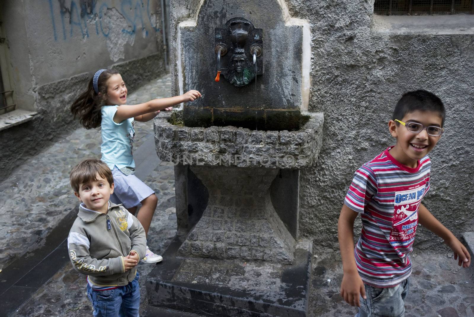 PLAYING WITH WATER, LONGOBUCCO, ITALY, SEPTEMBER 15 - 2011:  Kids in a narrow alley in the mountain village Longobucco, Calabria - Italy. 