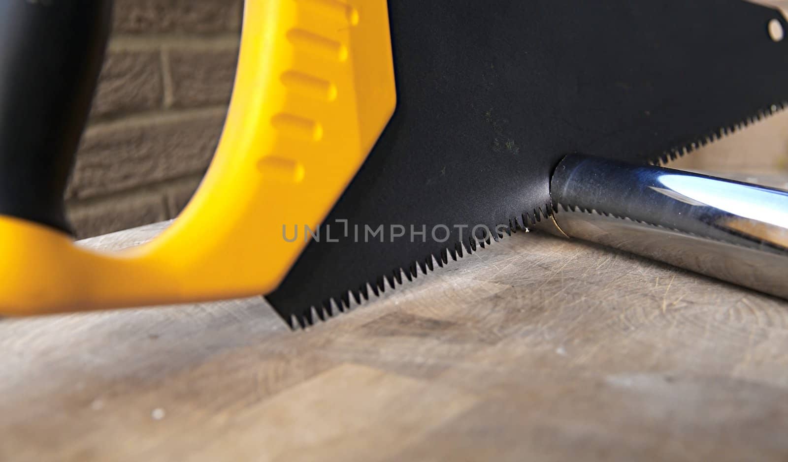 Wooden saw used for cutting a metal pipe by baggiovara