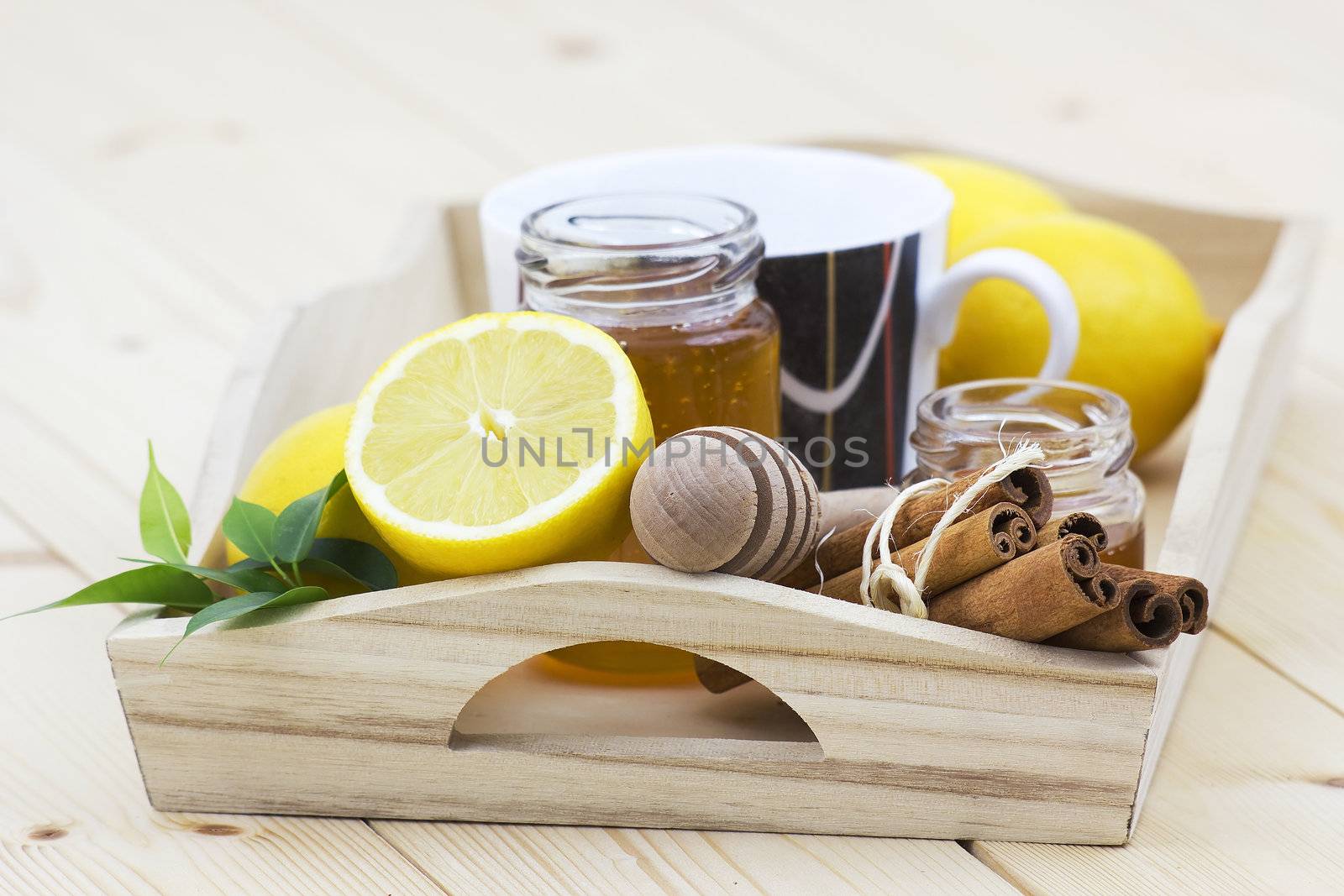 cup of tea, honey, cinnamon sticks and fresh lemons