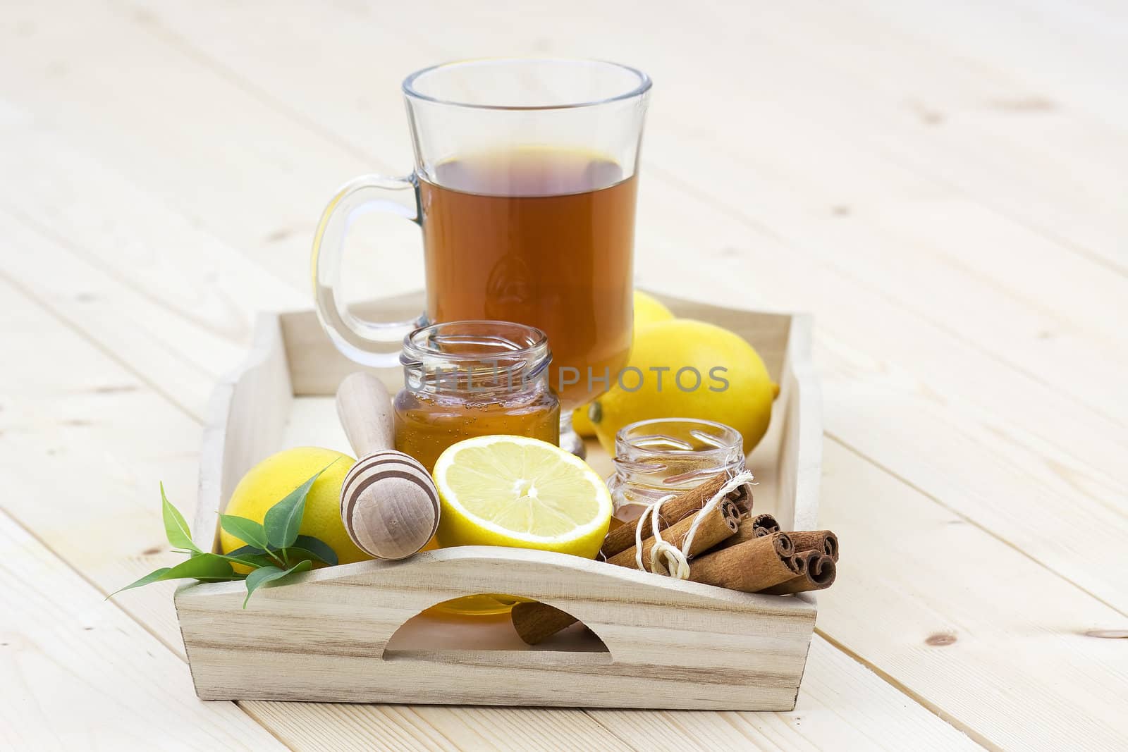 glass of tea, honey, fresh lemons and cinnamon sticks