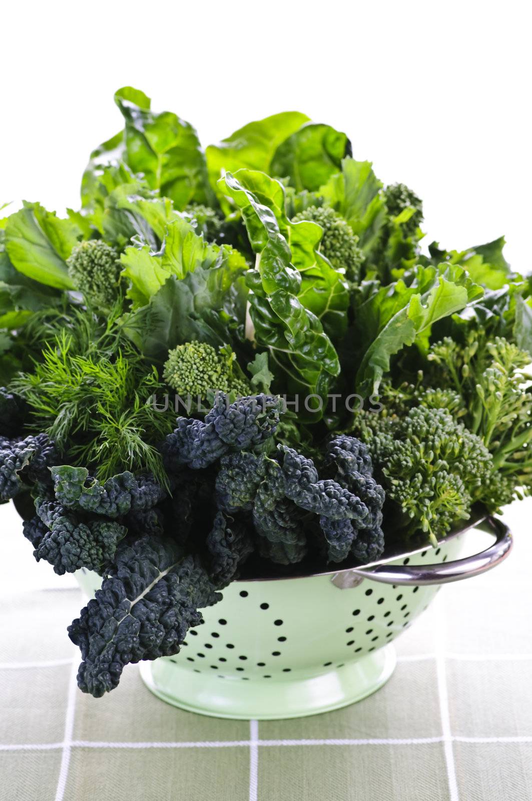 Dark green leafy fresh vegetables in metal colander