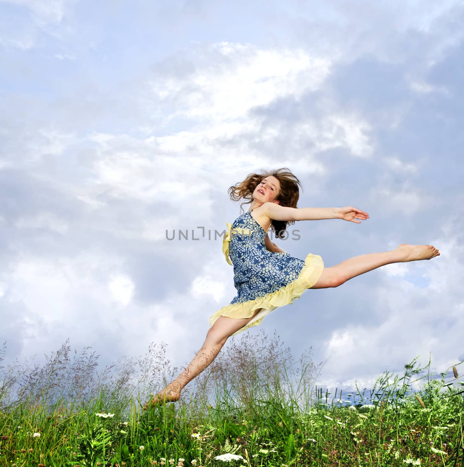 Young girl jumping in meadow by elenathewise